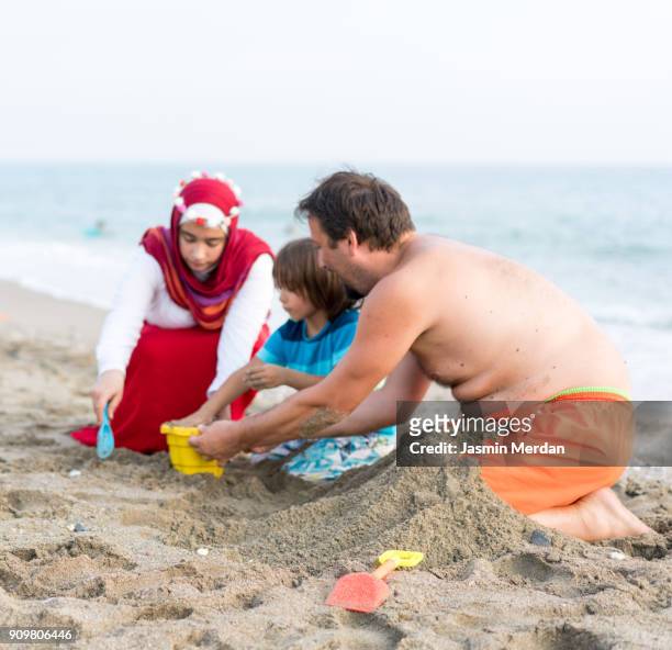 Muslim family in beach sand together