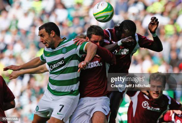 Scott McDonald of Celtic tackles Lee Wallace and David Obua of Hearts during the Clydesdale Bank Scottish Premier league match between Celtic and...