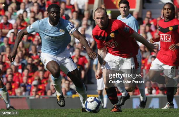 Wayne Rooney of Manchester United clashes with Kolo Toure of Manchester City during the FA Barclays Premier League match between Manchester United...