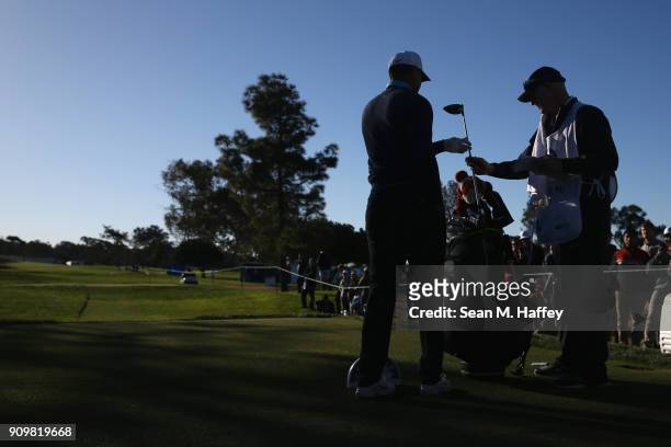 Caddy Joe LaCava hands Tiger Woods a club on the ninth hole during the pro-am round of the Farmers Insurance Open at Torrey Pines Golf Course on...