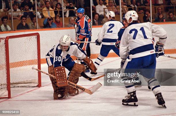 Don Edwards, Borje Salming and Gary Nylund of the Toronto Maple Leafs skate against Wayne Gretzky of the Edmonton Oilers during NHL preseason game...