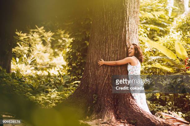 young woman hugging the tree - big hug stock pictures, royalty-free photos & images