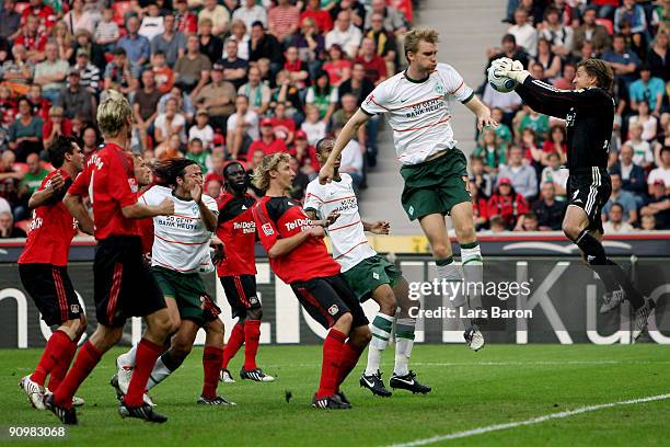 Goalkeeper Rene Adler catches the ball in front of Per Mertesacker of Bremen during the Bundesliga match between Bayer Leverkusen and Werder Bremen...