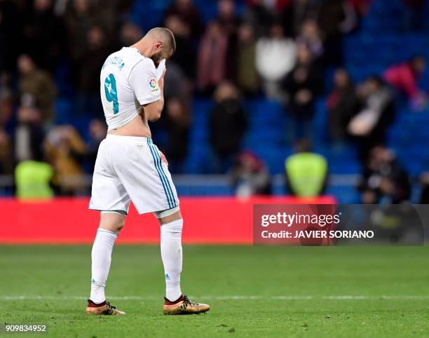 Real Madrid's French forward Karim Benzema wipes his face at the end of the Spanish 'Copa del Rey' quarter-final second leg football match between...