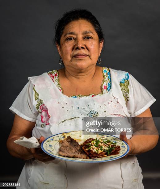 Elvia Valle Jimenez shows her dish of dried beef and dry-cured smoked beef prepared at her "Chofi" restaurant in the 20 de Noviembre market in...