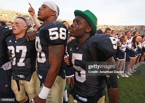 Mike Anello, Brian Smith and Armando Allen, Jr. #5, of the Notre Dame Fighting Irish sing with students after a win over the Michigan State Spartans...