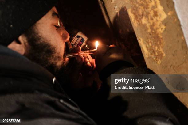Man smokes crack under a bridge where he lives with other addicts in the Kensington section of Philadelphia which has become a hub for heroin use on...