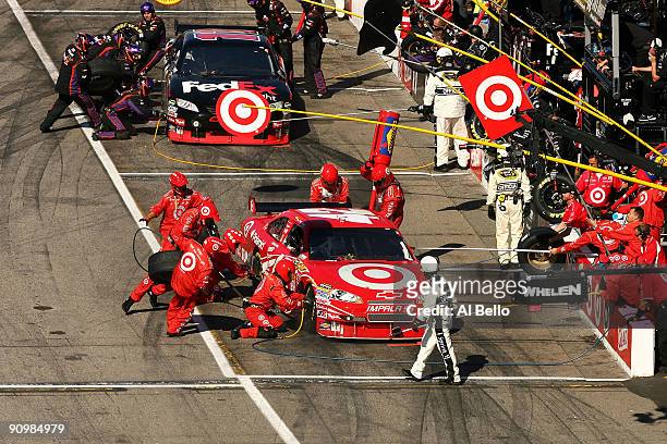 Juan Pablo Montoya, driver of the Target Chevrolet and Denny Hamlin, driver of the FedEx Freight Toyota, make a pit stop during the NASCAR Sprint Cup...