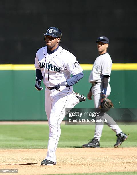 Ken Griffey Jr. #24 of the Seattle Mariners rounds the bases past shortstop Derek Jeter of the New York Yankees after hitting a three-run homer on...