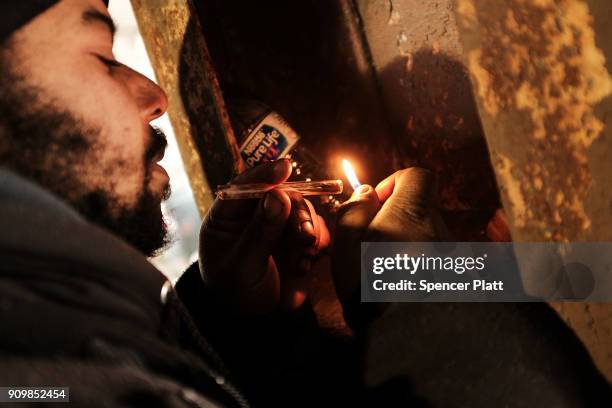 Man smokes crack under a bridge where he lives with other addicts in the Kensington section which has become a hub for heroin use on January 24, 2018...