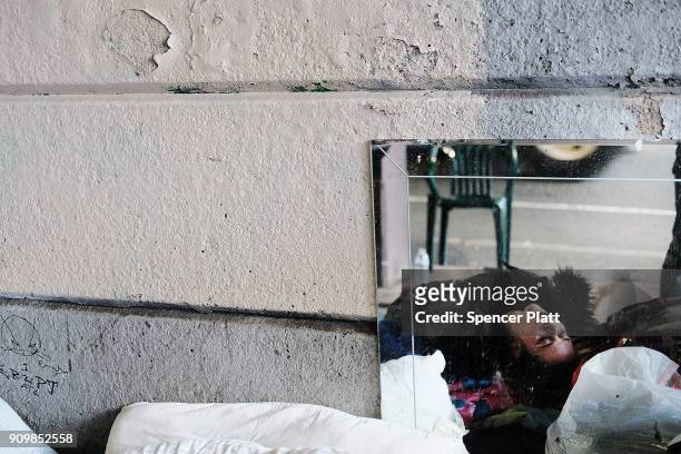 Woman, passed out on heroin, is reflected in a mirror under a bridge where she lives with other addicts in the Kensington section which has become a...