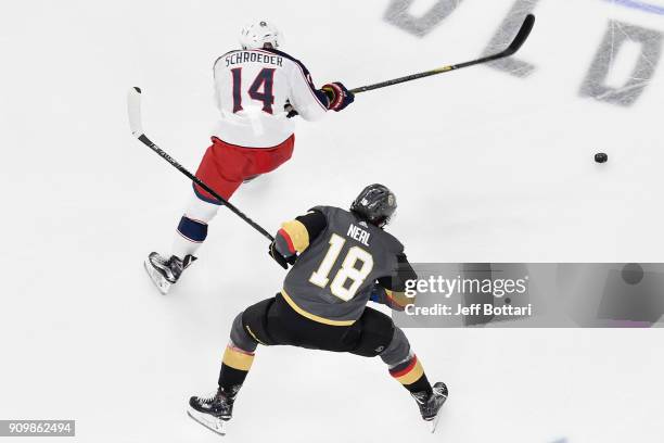 James Neal of the Vegas Golden Knights and Jordan Schroeder of the Columbus Blue Jackets skate to the puck during the game at T-Mobile Arena on...