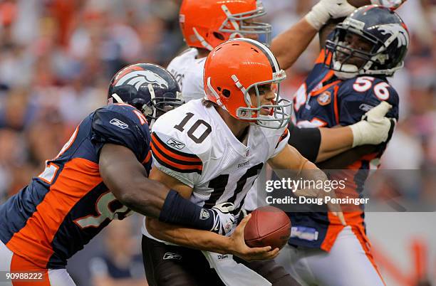 Quarterback Brady Quinn of the Cleveland Browns is sacked by defensive end Elvis Dumervil of the Denver Broncos as linebacker Robert Ayers looks to...