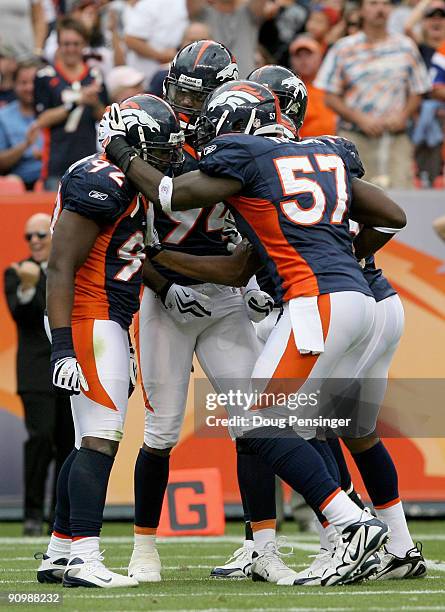 Defensive end Elvis Dumervil of the Denver Broncos is congratulated by his teammates after he sacked quarterback Brady Quinn of the Cleveland Browns...