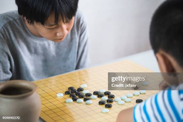 sister and brother playing the go game at home - go board game stock pictures, royalty-free photos & images