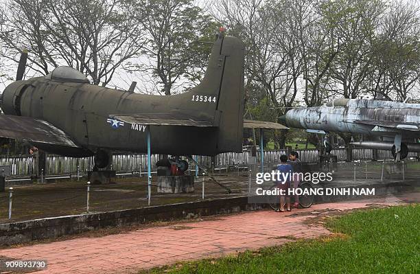 In this picture taken on January 16 children play next to a US Navy Douglas A-1 Skyraider captured during the war, and a Soviet-made MiG-21 aircraft...