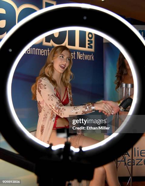 Adult film actress Alexa Grace, shown through a ring light, greets attendees at the Adult Entertainment Broadcast Network booth at the 2018 AVN Adult...