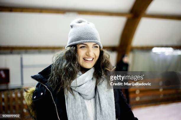 attraente giovane donna pattinaggio su ghiaccio durante l'inverno - capelli ghiaccio foto e immagini stock