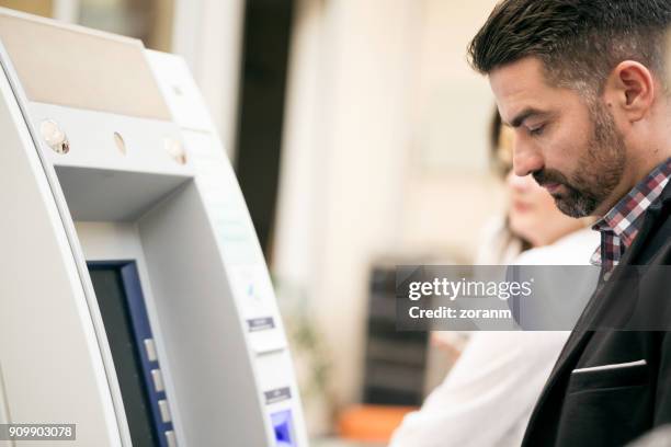 man at atm - bank fraud stock pictures, royalty-free photos & images