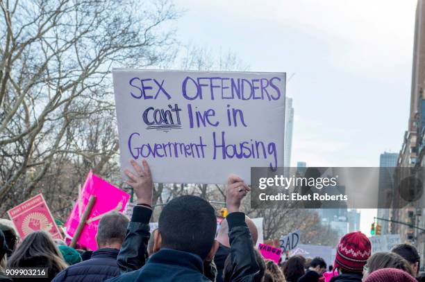 Marcher holds up a placard reading: 'Sex offenders can't live in government housing', at the 2018 Women's March in New York City on January 20, 2018.
