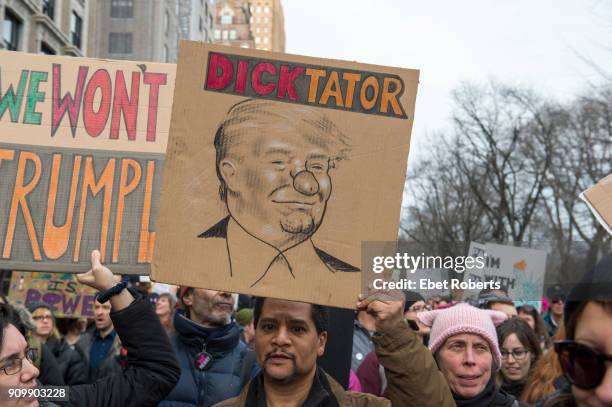 Marchers hold up placards protesting US President Donald Trump, at the 2018 Women's March in New York City on January 20, 2018.