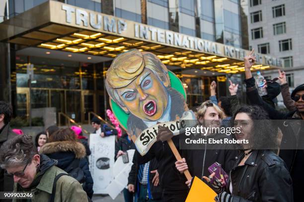 Marcher holds up a placard referring to alleged remarks by US President Donald Trump, in front of the Trump International Hotel and Tower, at the...