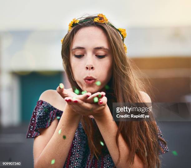 mooi meisje in bloem kroon blaast confetti uit handen - bloemkroon stockfoto's en -beelden
