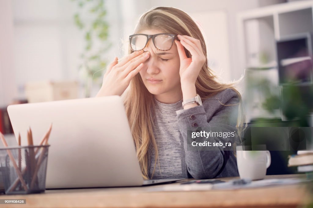 Young tired working woman at work