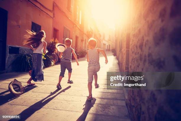 kids playing tag in mediterranean street - tag 11 stock pictures, royalty-free photos & images