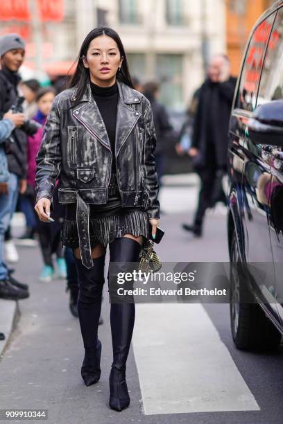 Tina Leung wears a black leather jacket, a fringe skirt, thigh high black leather boots, outside Elie Saab, during Paris Fashion Week - Haute Couture...