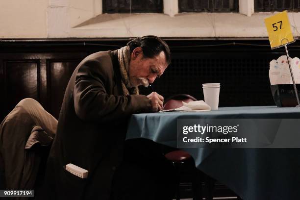 Peter Markopulos writes at a table at the Broad Street Ministry which serves thousands of free meals five days per week while also providing the...