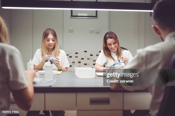 groep tandtechnici maken van kunstgebitten - extraction forceps stockfoto's en -beelden