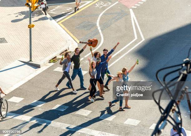 happy friends in der stadt. draufsicht der acht junge erwachsene über die straße in die sonne schaut in die kamera geschossen in barcelona, spanien. - straßenfest stock-fotos und bilder
