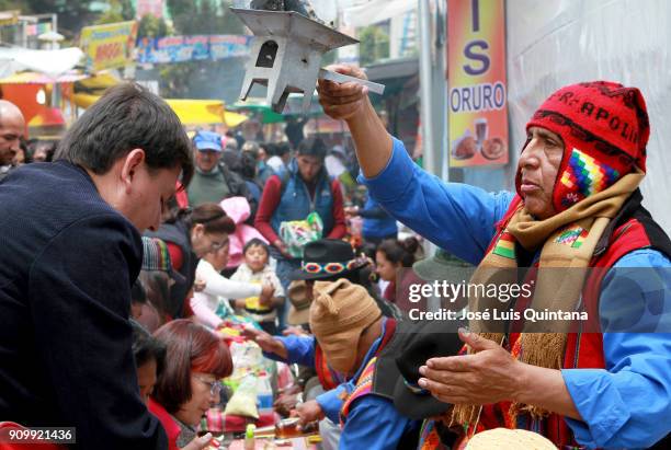 An Aymara priest, "Yatiris" performs a blessing, known as Ch`alla with alcohol and wine during the Alasitas festival on January 24, 2018 in La Paz,...