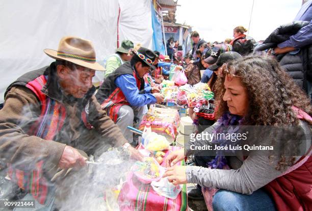 An Aymara priest, "Yatiris" performs a blessing, known as Ch`alla with alcohol and wine during the Alasitas festival on January 24, 2018 in La Paz,...