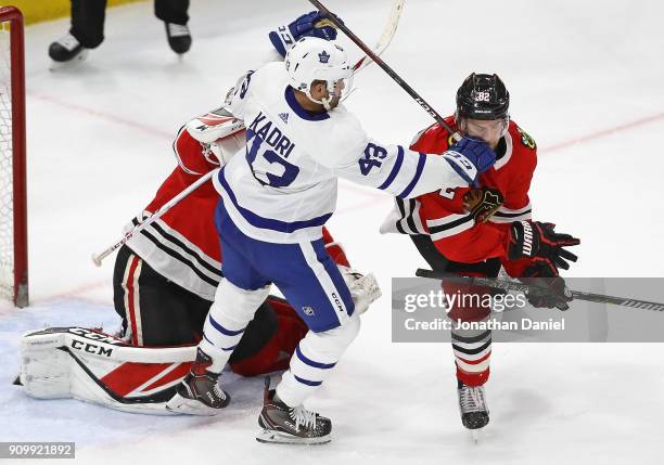 Nazem Kadri of the Toronto Maple Leafs hits Jordan Oesterle of the Chicago Blackhawks in the mouth in front of Jeff Glass at the United Center on...