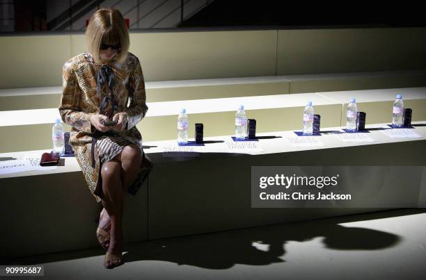 Editor of American Vogue Anna Wintour works on her blackberry as she sits on her own in the front row of the Meadham Kirchoff Spring/Summer 2010 show...