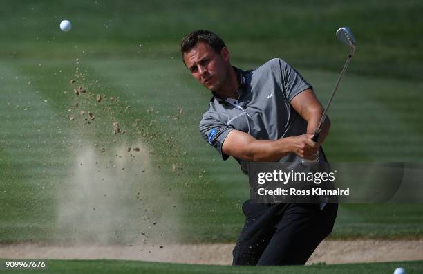Chris Hanson of England hits his third shot on the 13th hole during round one of the Omega Dubai Desert Classic at Emirates Golf Club on January 25,...