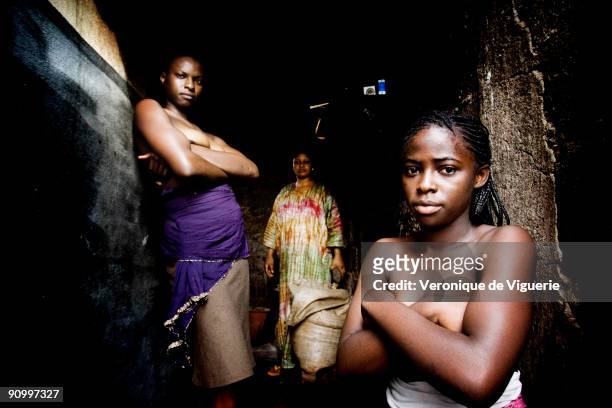 Philomene prepares to iron the breasts of two of her daughters Marianne and Carine with a hot stone which has been heated in the oven. In Cameroon,...