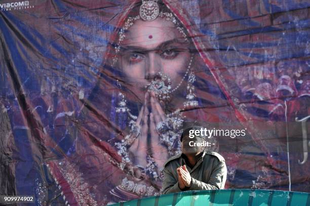 An Indian policeman gestures at the entrance of Ritz cinema hall scheduled to screen Bollywood film 'Padmaavat' in the northern hill town of Shimla...