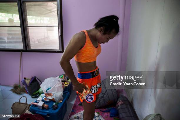 Thai transgender boxer Nong Rose changes out of her dress and into sports gear before a training routine at the Ban Charoensuk gym where she trains...