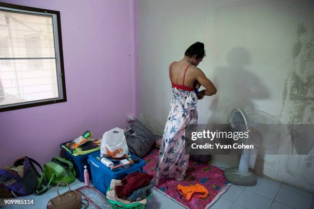 Thai transgender boxer Nong Rose changes out of her dress and into sports gear before a training routine at the Ban Charoensuk gym where she trains...