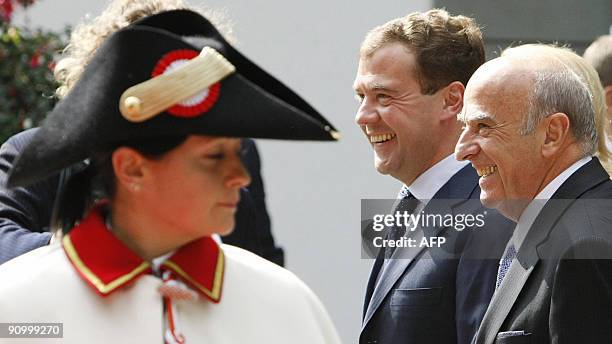 Russian President Dmitry Medvedev and Swiss counterpart Hans-Rudolf Merz smile behind a Swiss usher upon his arrival at the Lohn residency in...