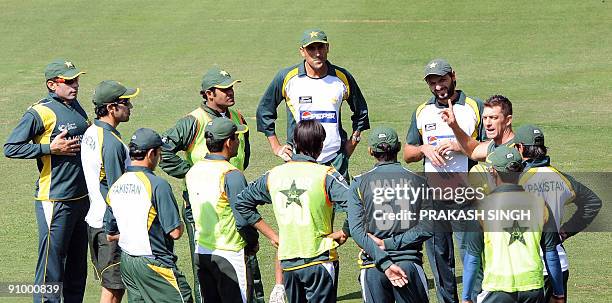 Pakistani captain Younus Khan along with other teammates listens to physical trainer David Dyer during a training session at Wanderers in...