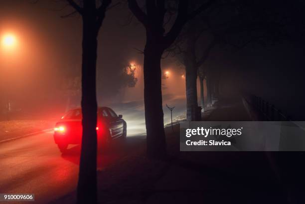 moving car and walkway on misty night - dark alley stock pictures, royalty-free photos & images