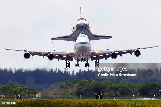 Space Shuttle Discovery, mounted atop a modified Boeing 747 shuttle carrier, touches down on the shuttle landing facility at NASA's Kennedy Space...