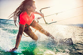 Smiling young female kiteboarder on the sea