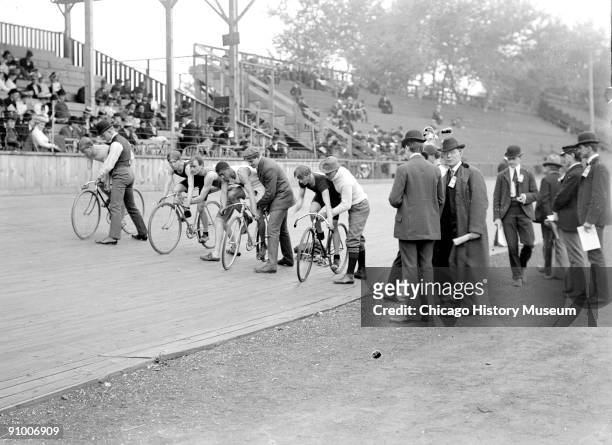 Image of four cyclists, including one African American, positioning on a wooden track to begin a race at a velodrome in Chicago, Illinois, 1901....