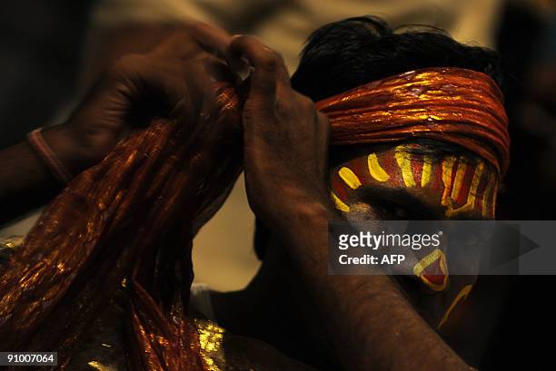 Indian stage artist, Raghuveer gets ready to perform prior to the start of a stage show of 'Ram Leela' in Allahabad late on September 21, 2009. 'Ram...