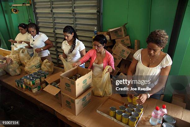 Beth Frazier, Carol Echeverria, Angie Solomon and Andrea Bloomfield along with other volunteers sort food into individual bags to be given out at...